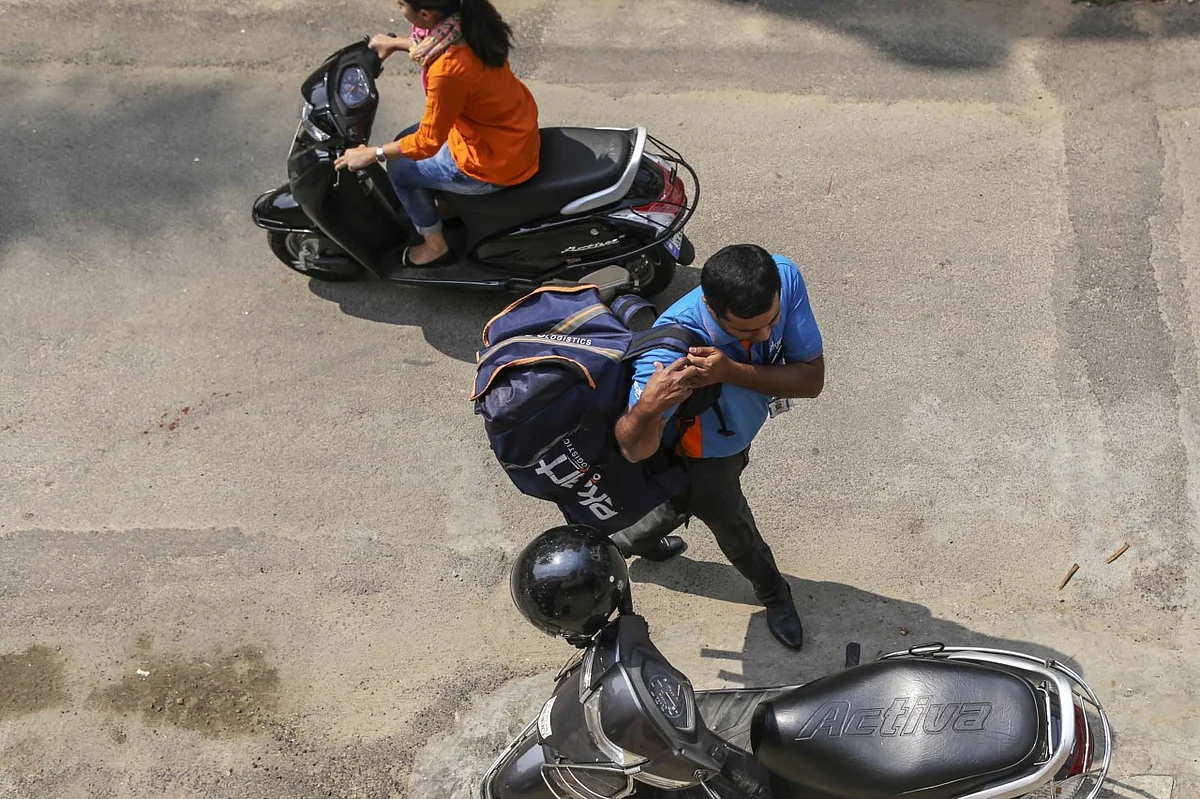 Abdul Saleem carries his bag back to his scooter (Photographer: Dhiraj Singh/Bloomberg)