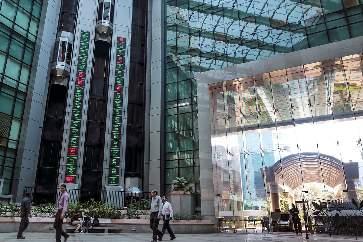 

Employees walk past by electronic ticker boards that indicate the latest stock figures inside the atrium at the National Stock Exchange (NSE) in Mumbai (Photographer: Dhiraj Singh/Bloomberg)
