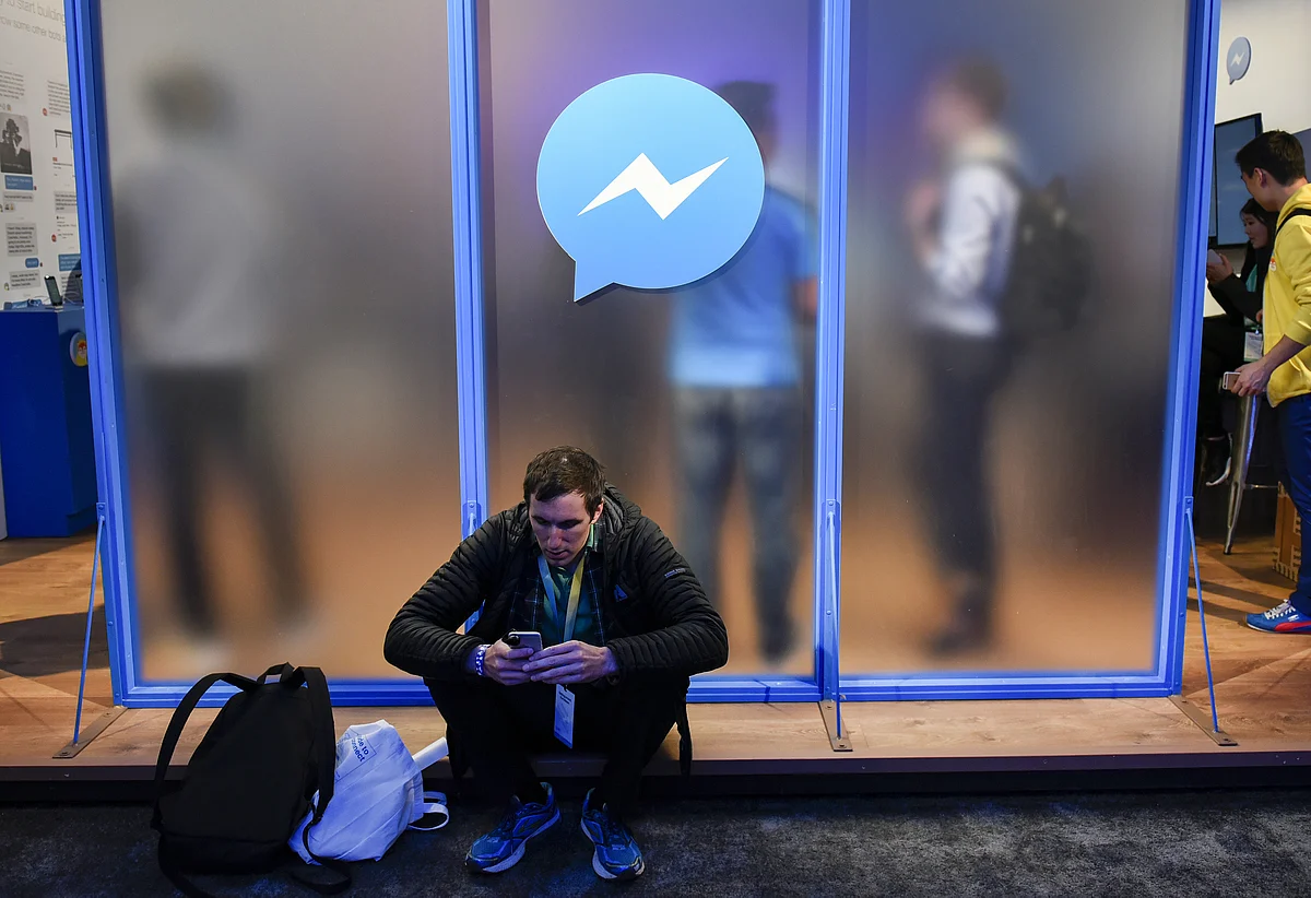 An attendee sits in front of a messenger logo during the Facebook F8 Developers Conference in San Francisco, California, U.S., on Tuesday, April 12, 2016. Facebook Inc. (Photographer: Michael Short/Bloomberg)