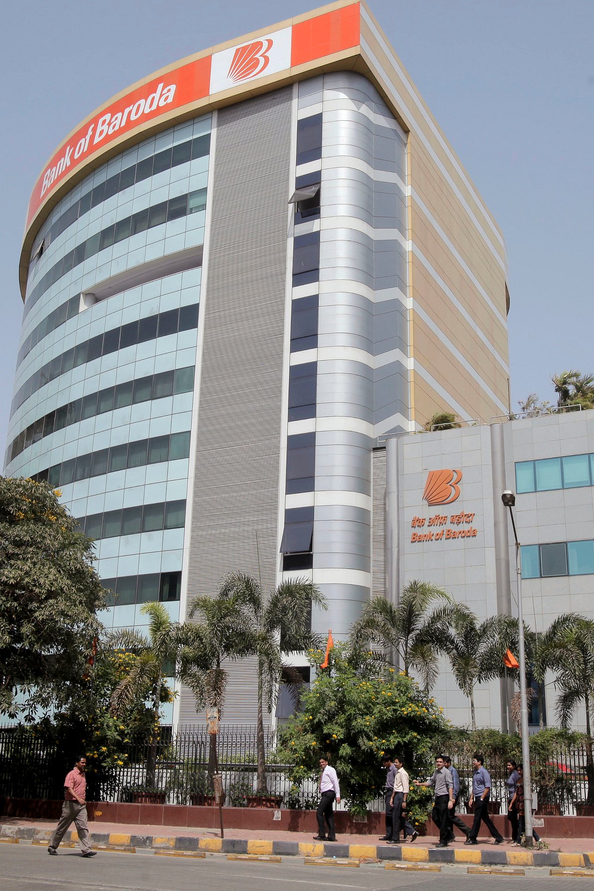  Pedestrians walk past the Bank of Baroda building in Mumbai, India. (Photographer: Adeel Halim/Bloomberg)