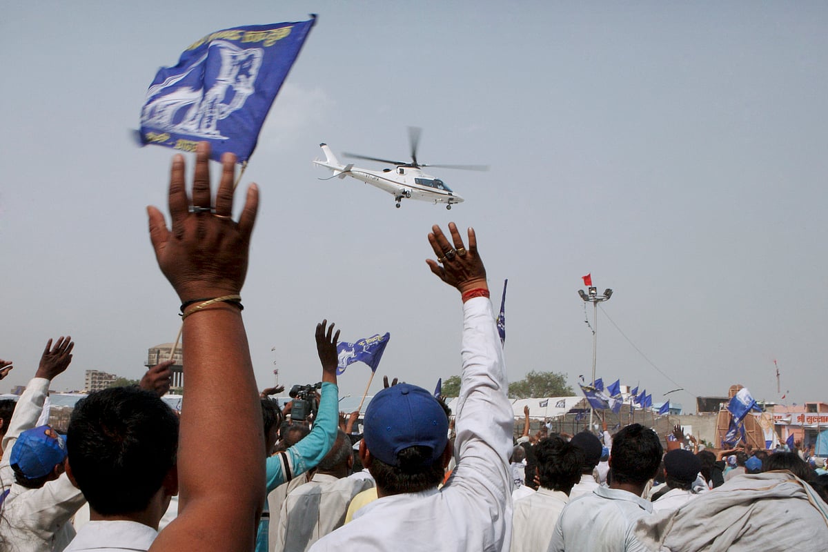 Supporters of the Bahujan Samaj Party wave at the helicopter transporting Mayawati following a campaign rally in Ghaziabad, India. (Photographer: Pankaj Nangia/Bloomberg News)