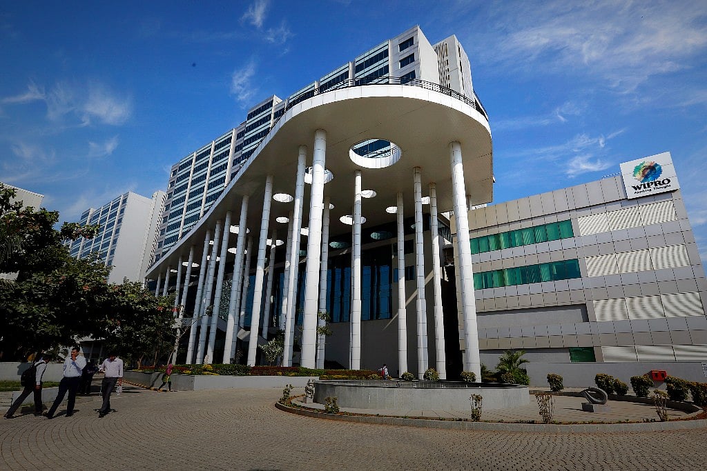 Employees walk in the forecourt of a Wipro building at the Wipro Ltd. campus located in the Sarjapura area of Bangalore, India (Photographer: Vivek Prakash/Bloomberg) 