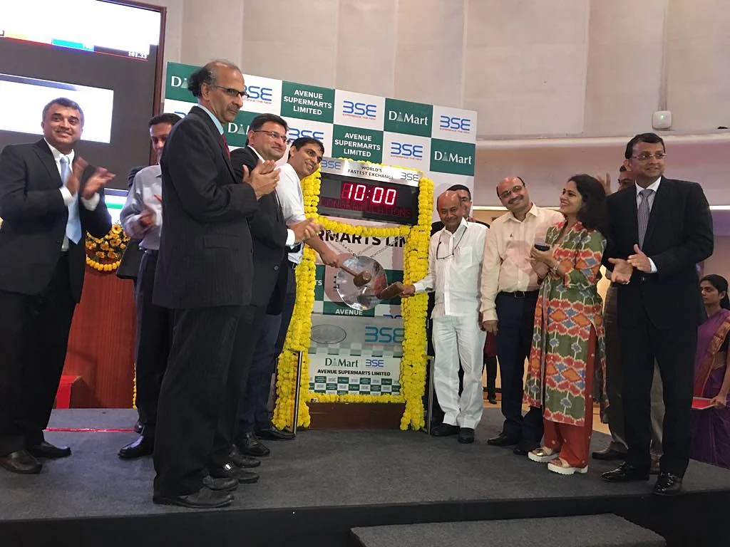 Radhakrishan Damani, majority stakeowner of Avenue Supermarts (fourth from right) rings the IPO bell at Avenue Supermart’s listing at the Bombay Stock Exchange. (Photographer: Sharleen Dsouza/BloombergQuint)