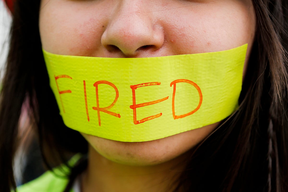 An employee fired from the job, wears a piece of tape across her mouth during a demonstration (Photographer: Patrick T. Fallon/Bloomberg)