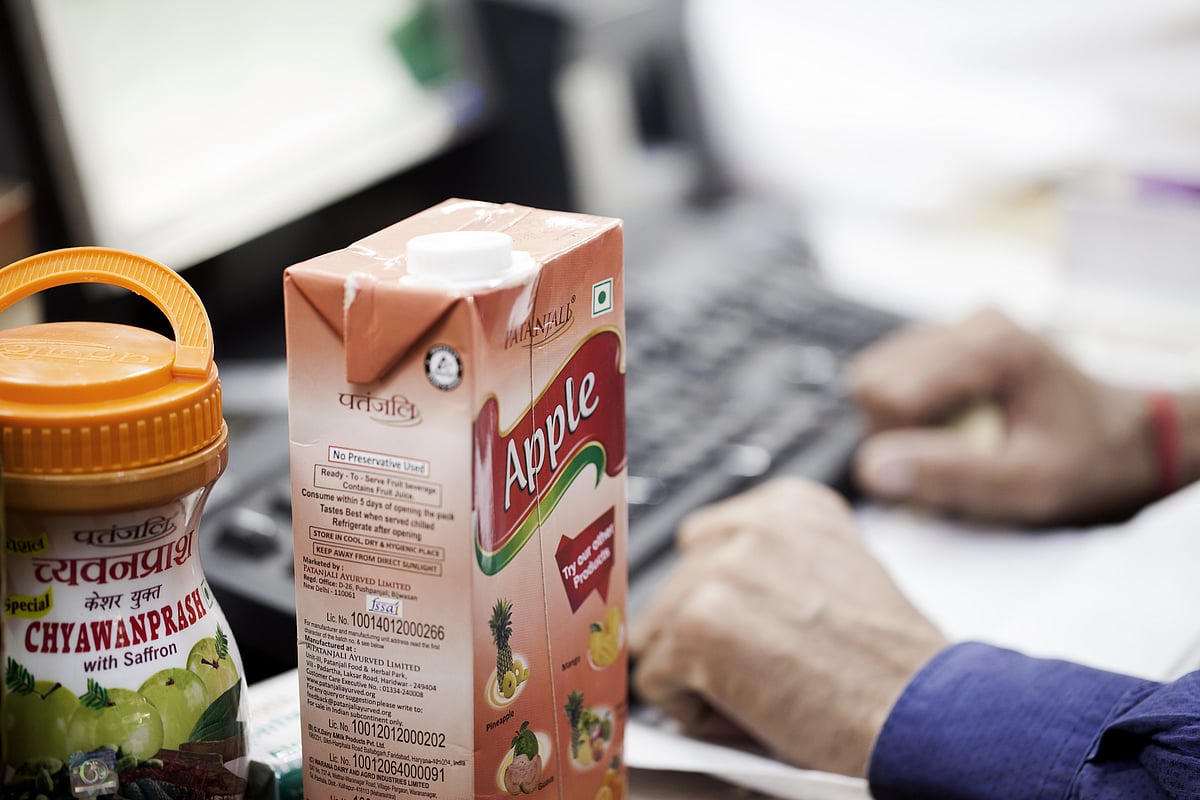 

A container of chyawanprash and a carton of apple juice sit on a counter at a Patanjali Ayurved Ltd. store. (Photographer: Udit Kulshrestha/Bloomberg)