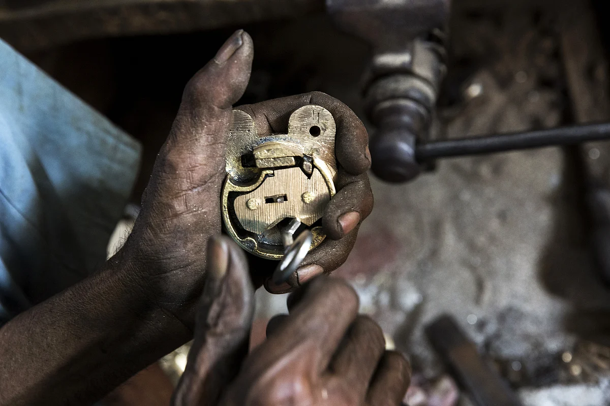 A worker manufactures a lock at a workshop in Aligarh, Uttar Pradesh, India. (Photographer: Udit Kulshrestha/Bloomberg)