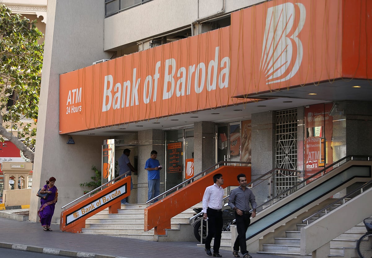 Pedestrians pass a Bank of Baroda bank branch. (Photographer: Chris Ratcliffe/Bloomberg)