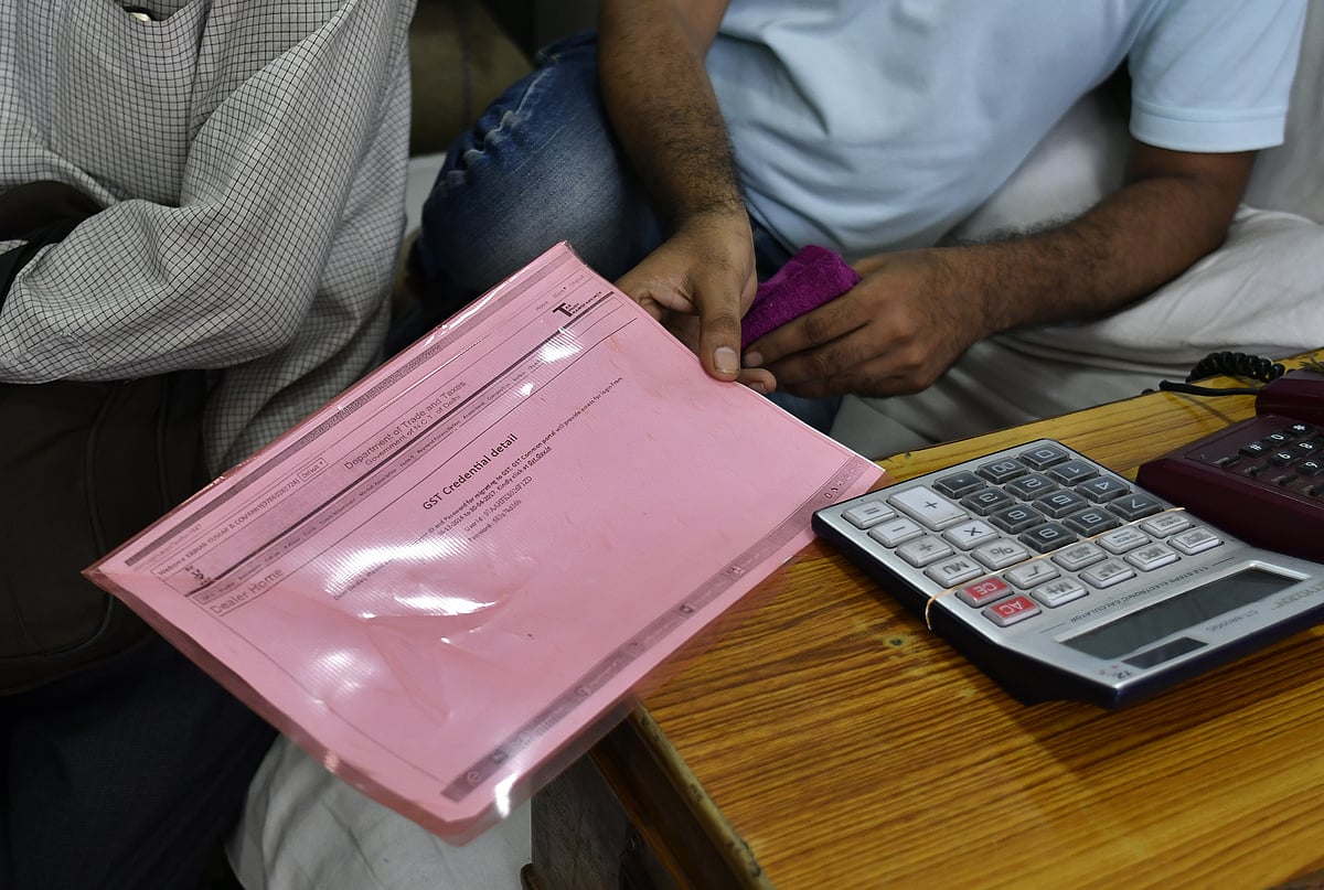 A worker holds his goods and services tax papers. (Photographer: Anindito Mukherjee/Bloomberg)
