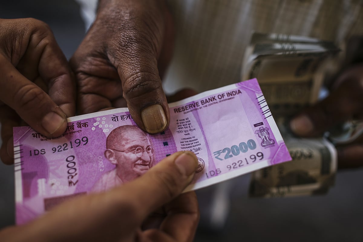 

Men hold a two thousand Indian rupee banknote for a photograph (Photographer: Dhiraj Singh/Bloomberg)