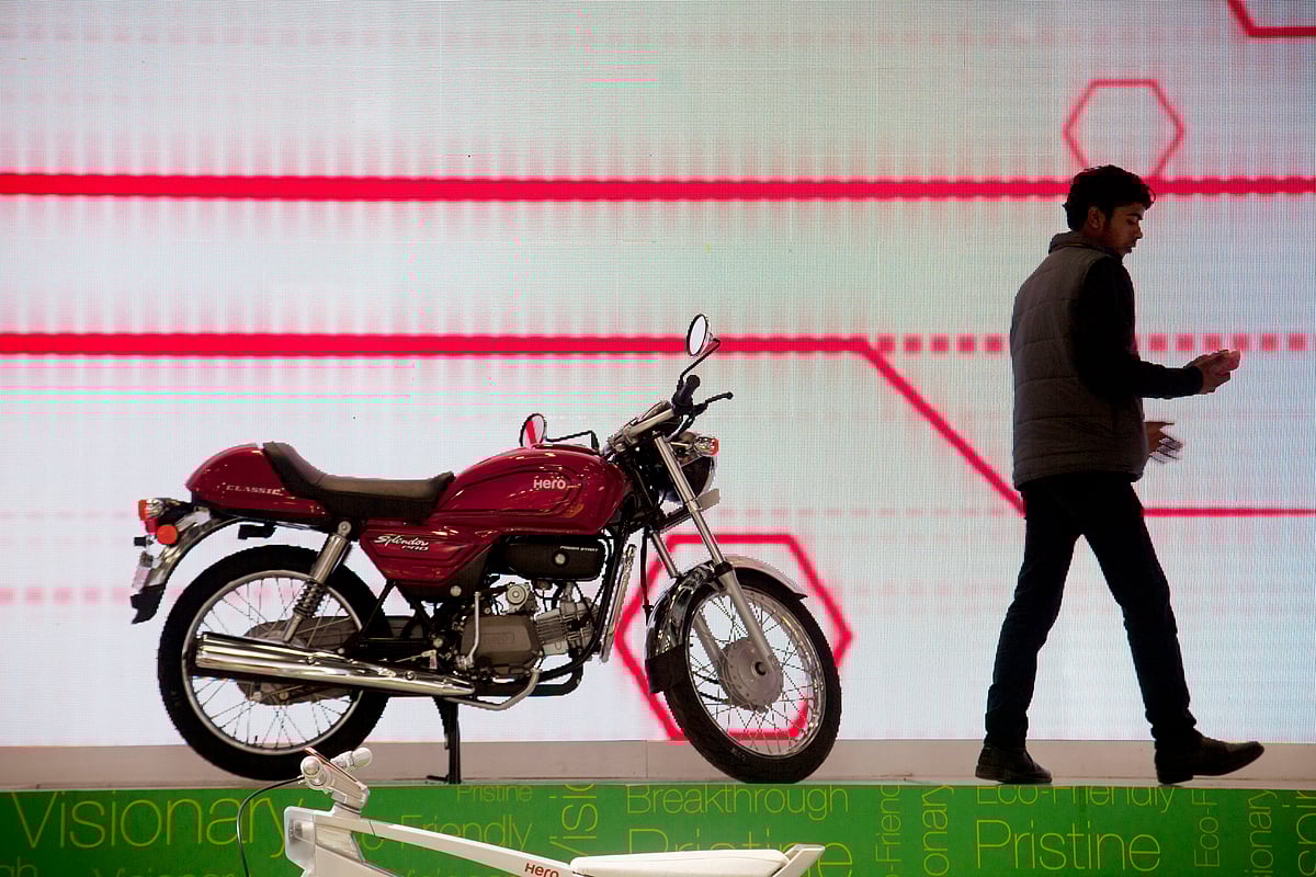 

An employee walks past a Hero MotoCorp Ltd. Splendor Pro motorcycle. (Photographer: Kuni Takahashi/Bloomberg)