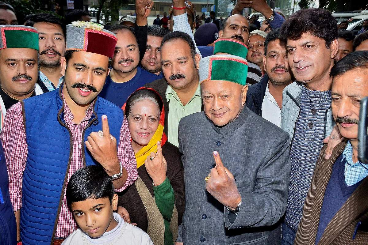 Himachal Pradesh Chief Minister Virbhadra Singh with wife Partibha Singh and son Vikrmaditya Singh showing their inked finger after they cast their vote at a polling booth, in Rampur. (Source: PTI)