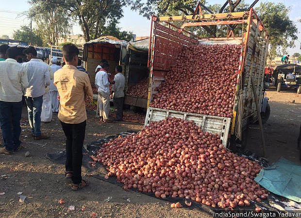 Trucks unload onions at the Pimpalgaon Agricultural Produce Market Committee (APMC) in Nashik, one of the few APMC markets that pay farmers in cash. Farmers prefer to accept a lower rate for a cash payment, instead of accepting cheques that take weeks to encash and often bounce.