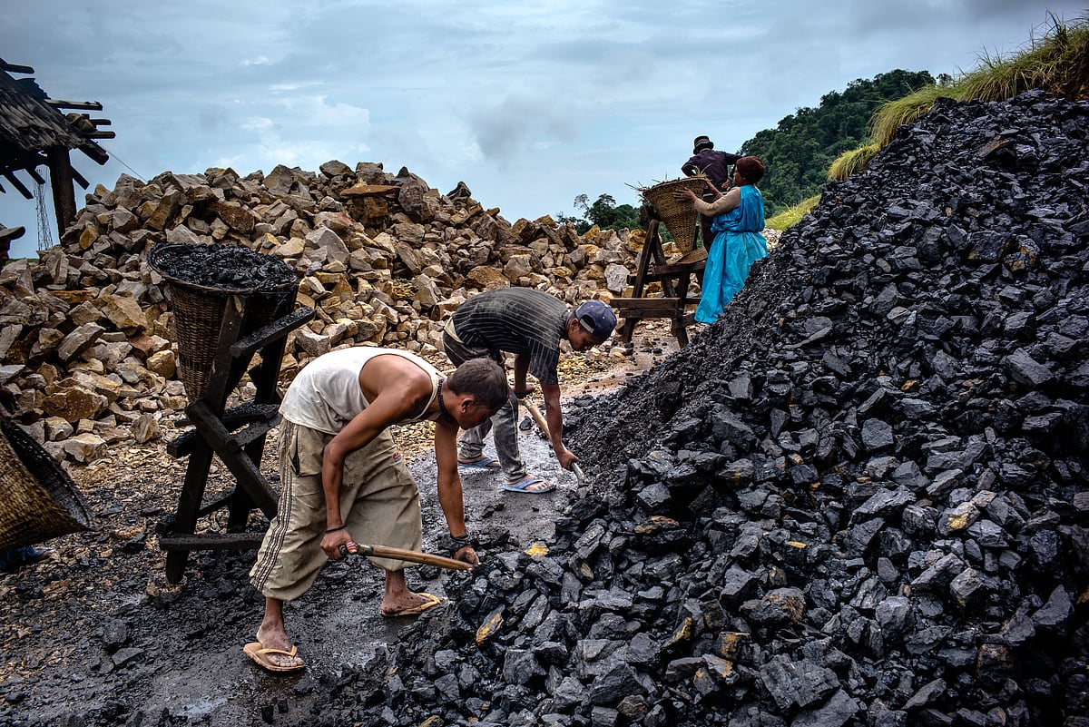 Daily wage labourers shovel coal into baskets at a limestone quarry in Lower Cherrapunji in Meghalaya, India. (Photographer: Sanjit Das/Bloomberg)