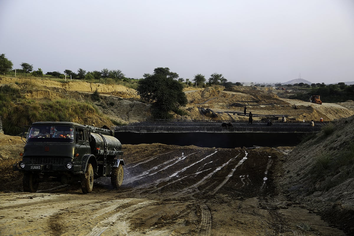 A worker drives a water tanker at the construction site of a road in Islamabad, Pakistan. (Photographer: Asad Zaidi/Bloomberg)