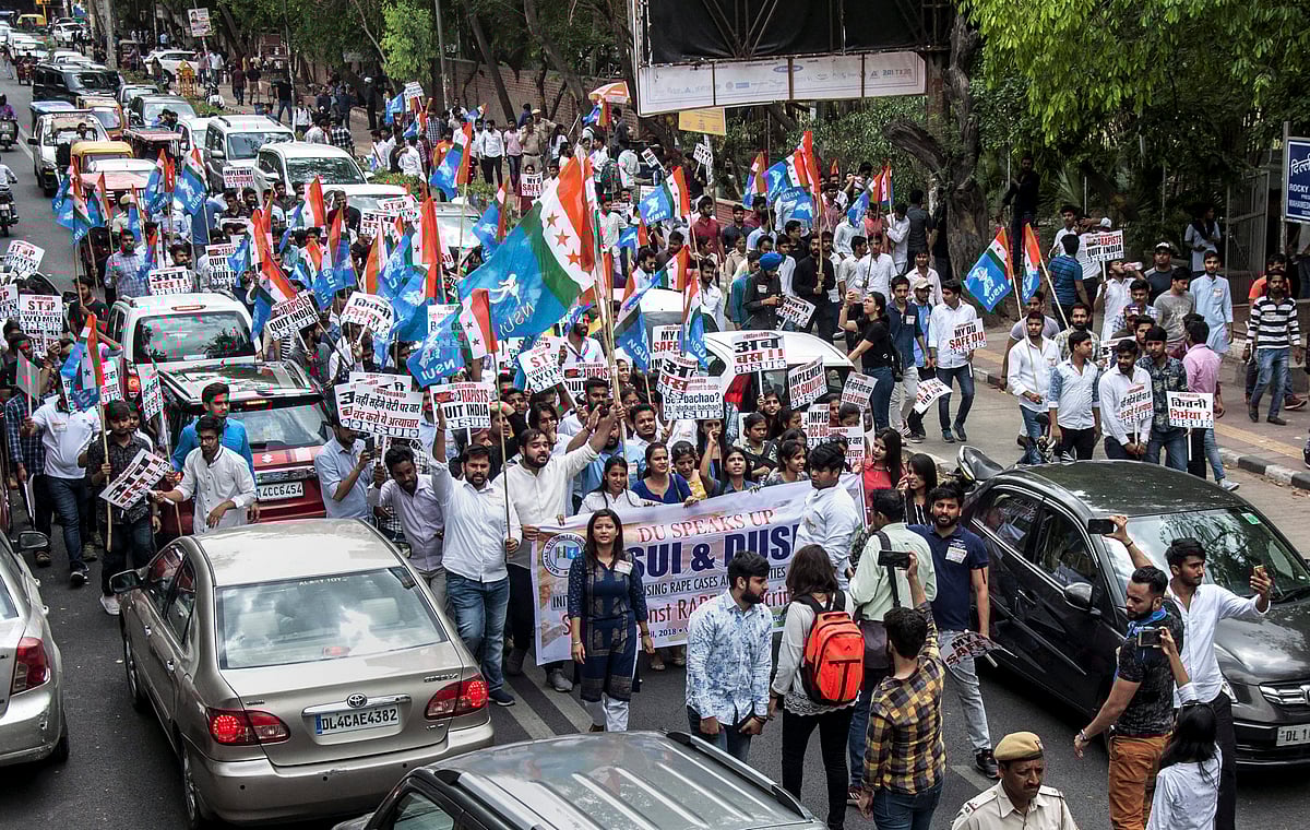 NSUI and DUSU activists display placards and shout slogans during a protest march against rape cases, atrocities against women and various other issues, in North Campus, Delhi University on Friday. (Source: PTI)