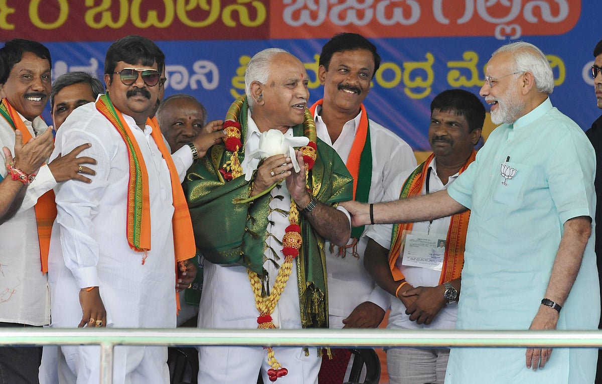 Prime Minister Narendra Modi and BJP’s chief ministerial candidate BS Yeddyurappa share a lighter moment during Karnataka election campaign rally at Chamarajanagar. (Photograph: PTI)