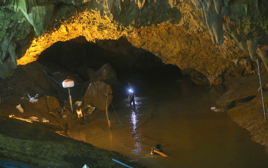Rescuers walk out of the entrance to a cave complex where 12 soccer team members and their coach went missing, in Mae Sai, Chiang Rai province, in northern Thailand (Source: PTI)