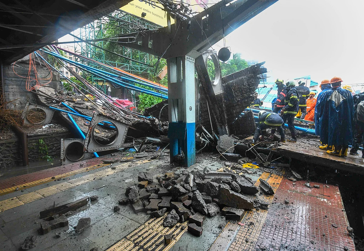Rescue workers clear the debris of Gokhale foot overbridge that collapsed on the Western Railway tracks, at Andheri station following heavy rain, in Mumbai on Tuesday, (Photographer: Shirish Shete/PTI)