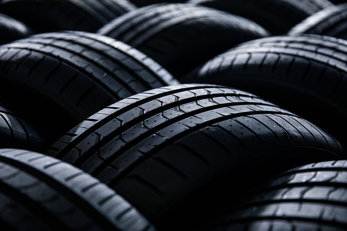 Automobile tyres sit stacked in a storage area at a plant. (Photographer: Akos Stiller/Bloomberg)