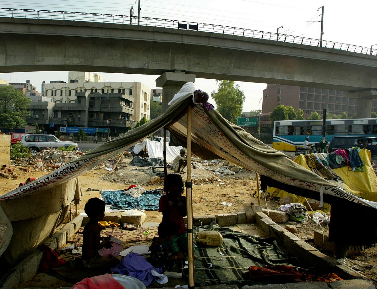 Children sit in their tents pitched in the middle of a busy road in New Delhi, India (Photographer: Amit Bhargava/Bloomberg News.) &nbsp;