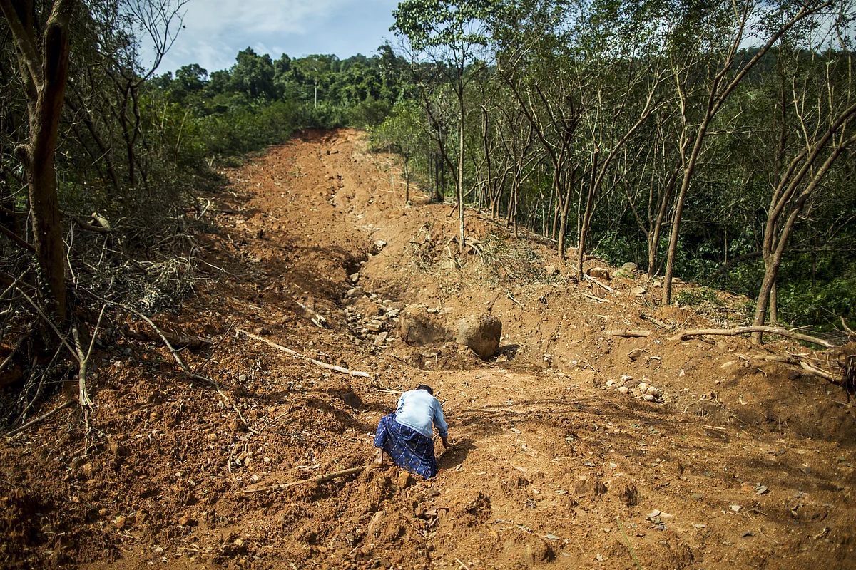 A farmer looks at land damaged by a landslide at a rubber plantation in Vannappuram village in the district of Idukki, Kerala, India. (Photographer: Prashanth Vishwanathan/Bloomberg)