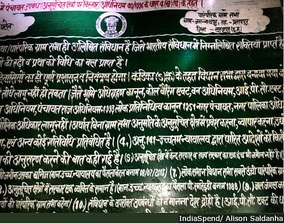Sections of the Constitution, the Forest Rights Act and the Panchayat Extension to Scheduled Areas Act, painted on a green board and erected near villages in Surajpur district, northern Chhattisgarh. Villagers are yet to receive individual or community forest rights.