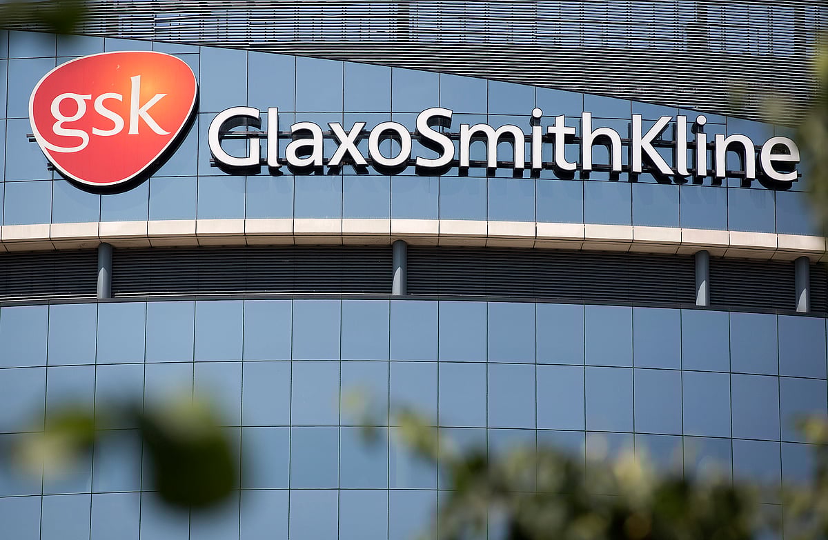 A GlaxoSmithKline Plc logo sits on glass windows at the company’s headquarters in London, U.K. (Photographer: Simon Dawson/Bloomberg)