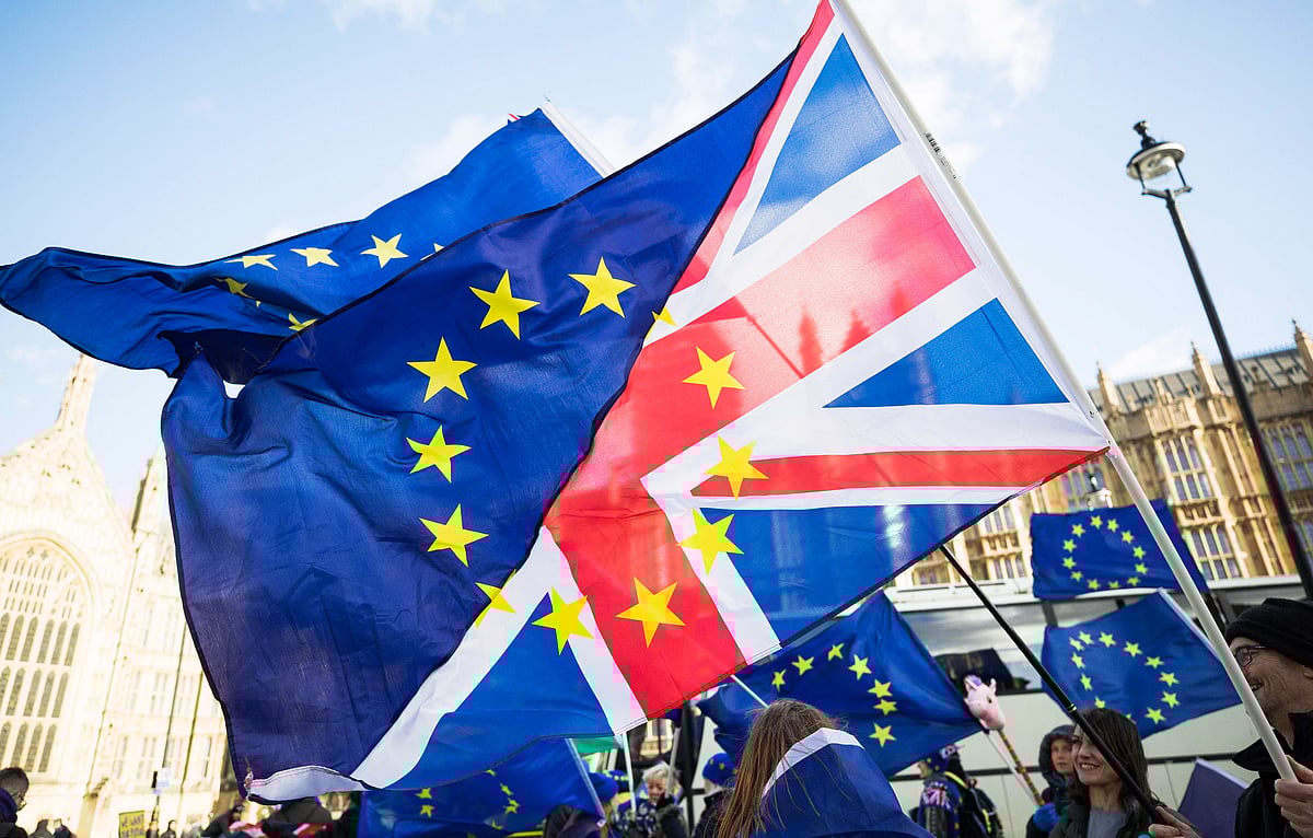 Anti-Brexit protesters wave flags  outside the Houses of Parliament in London. (Photographer: Chris Ratcliffe/Bloomberg)