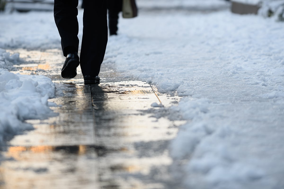 A commuter walks on a snow covered sidewalk. (Photographer: Akio Kon/Bloomberg)