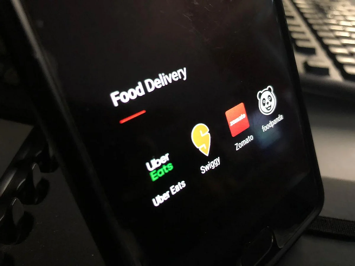 Application icons of UberEats, Swiggy, Zomato and Foodpanda are visible on a phone. (Source: BloombergQuint)