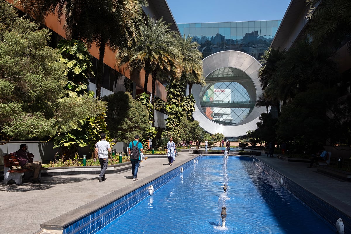 Employees walk past a water feature at Building 44 of the Infosys Ltd. campus in the Electronics City information technology hub in Bengaluru, India (Photographer: Karen Dias/Bloomberg) &nbsp;