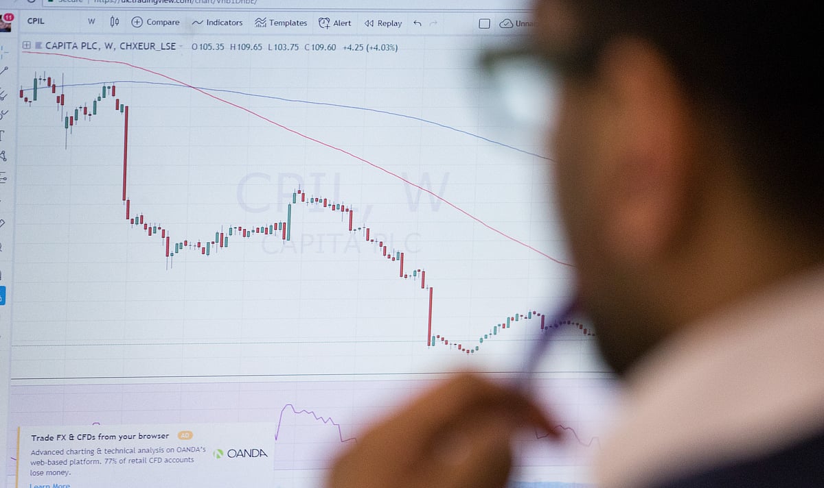 An investor monitors financial data  on computer screens on a trading floor. (Photographer: Chris Ratcliffe/Bloomberg)