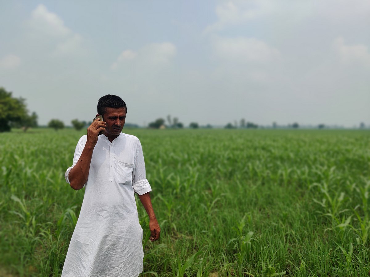 Sandeep Singh Roha, a farm activist based in the village of Ballah, Haryana in the fields speaking on the phone. Image Courtesy: Parth MN