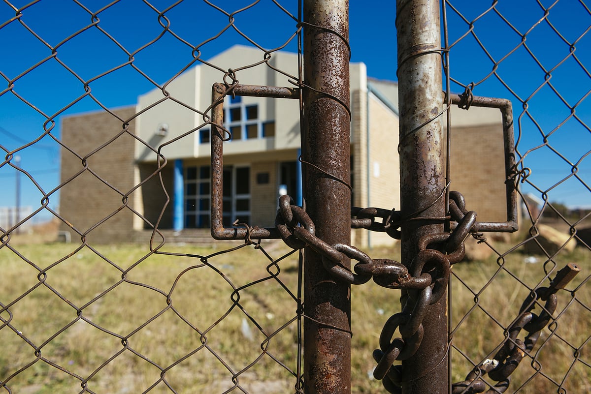  Locked rusty metal gates seal the grounds of the unused building. (Photographer: Waldo Swiegers/Bloomberg) 