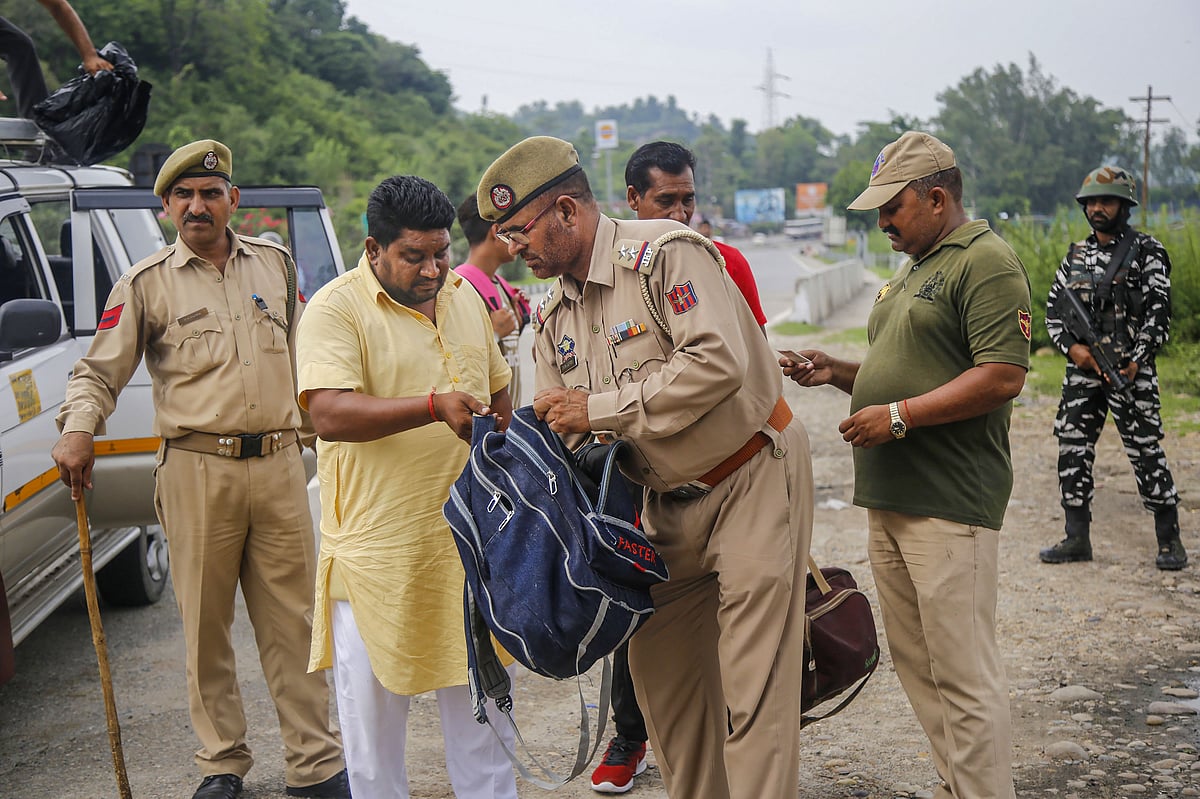 Police personnel check luggage of passengers of Kashmir bound vehicles ahead of Independence Day, on the outskirts of Jammu. (Spurce: PTI)