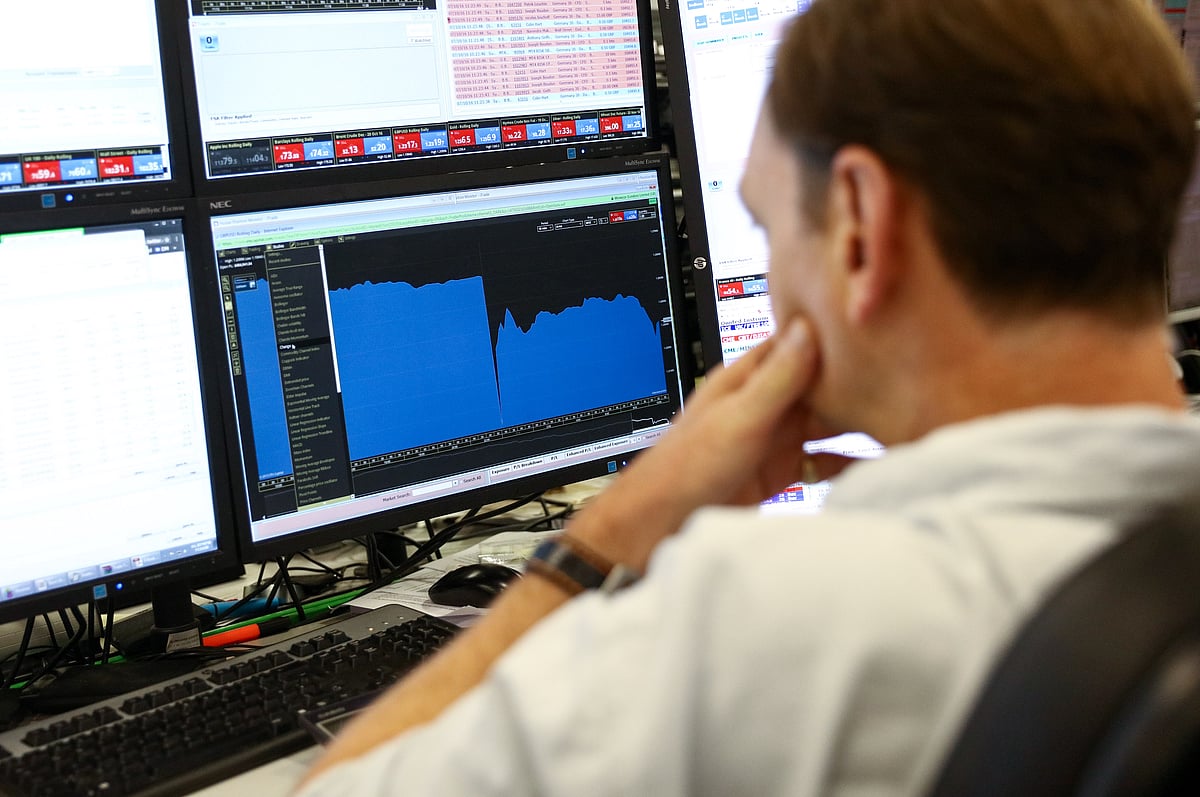 A trader monitors financial data on computer screens at ETX Capital, a broker of contracts-for-difference, in this arranged photograph in London. Photographer: Chris Ratcliffe/Bloomberg