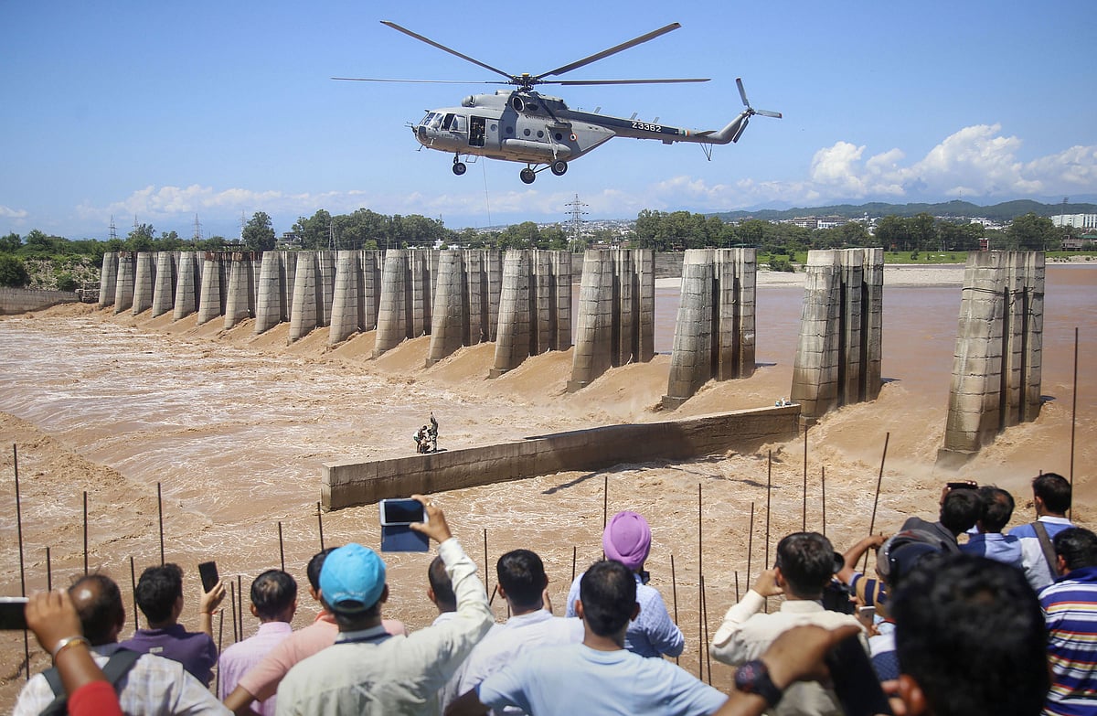 A chopper of the Indian Air Force approaches to airlift two persons stuck on an under-construction bridge at the flooded Tawi river in Jammu (Source: PTI)