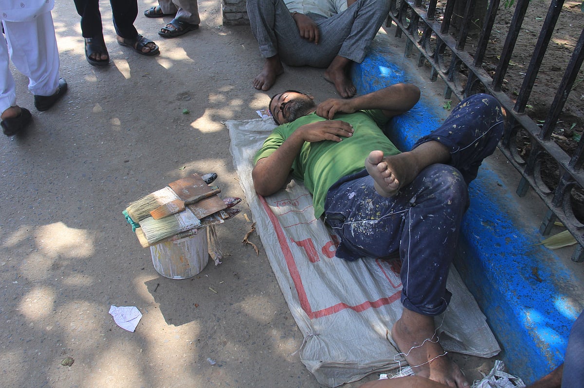 A painter, waiting for work, sleeps by the roadside near the Labour Chowk at Chandni Chowk in Delhi. (Photographer: Nishant Sharma/BloombergQuint)