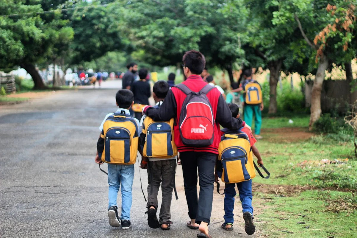 A volunteer accompanies children to school. (Photograph: Make A Difference)