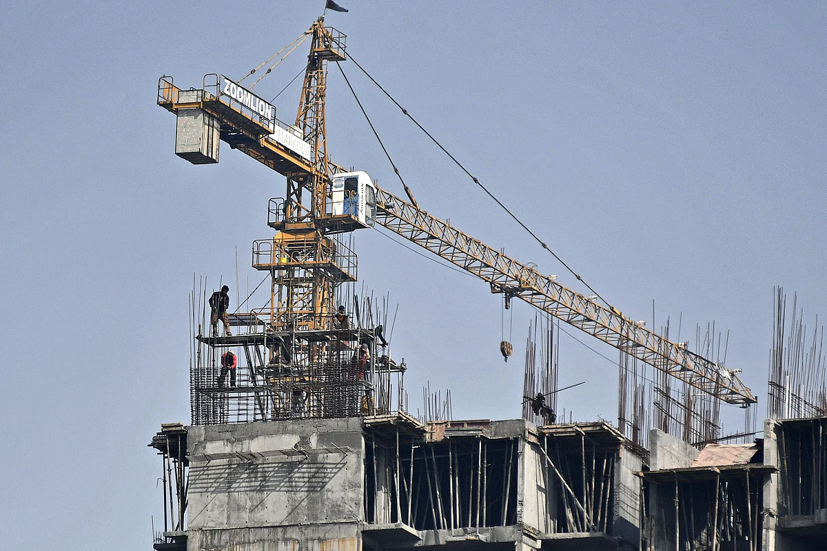 A crane operates on a residential building under construction at an Mahagun India Ltd. development in Noida, Uttar Pradesh, India. (Photographer: Anindito Mukherjee/Bloomberg)