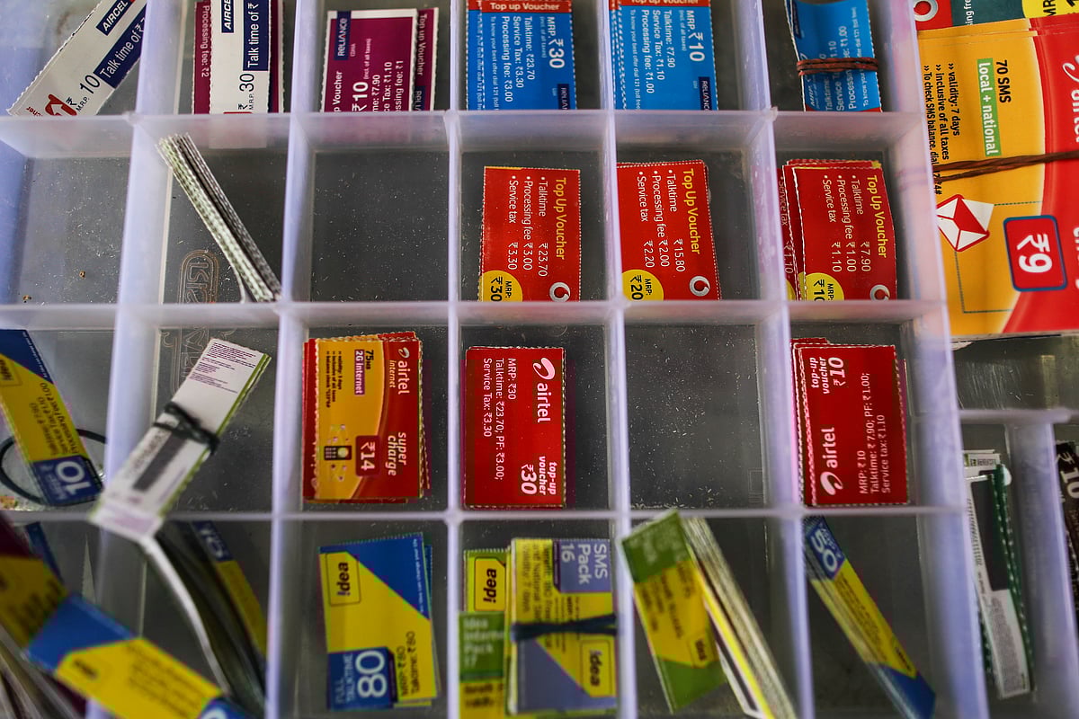 Top-up vouchers for Aircel Ltd., clockwise from top left, Reliance Communications Ltd., Vodafone Group Plc, Bharti Airtel Ltd., and Idea Cellular Ltd. sit inside a box (Photographer: Dhiraj Singh/Bloomberg)
