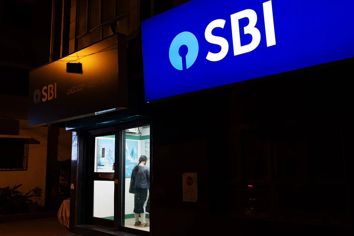 A customer uses an automated teller machine (ATM) at a State Bank of India Ltd. (SBI) branch at night in Bengaluru, India. (Photographer: Karen Dias/Bloomberg)