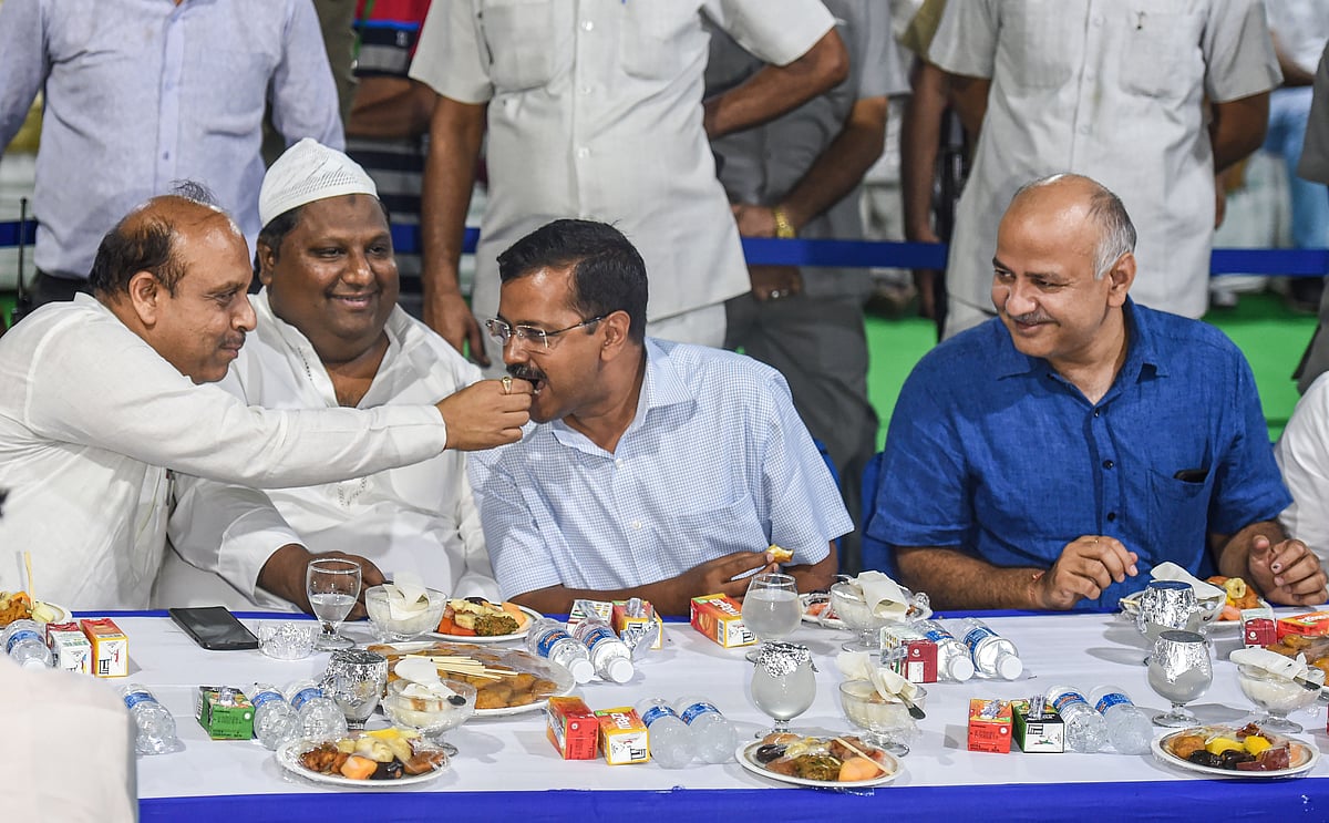 Arvind Kejriwal being offered a bite by BJP MLA Vijender Gupta as Manish Sisodia looks on, at an Iftar party in New Delhi, on June 3, 2019. (Photograph: PTI)
