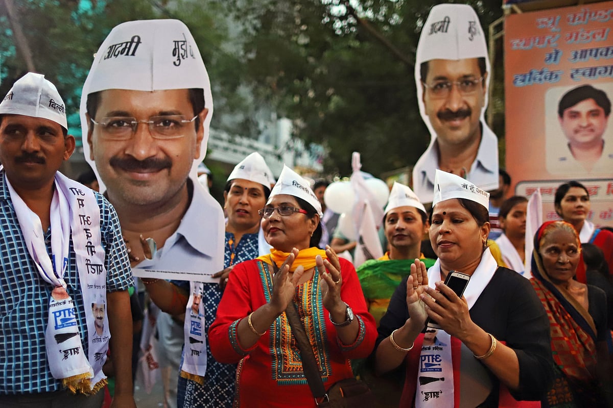 Supporters hold up cardboard cut-outs of Arvind Kejriwal during a campaign rally in New Delhi, India. (Photographer: Anindito Mukherjee/Bloomberg)