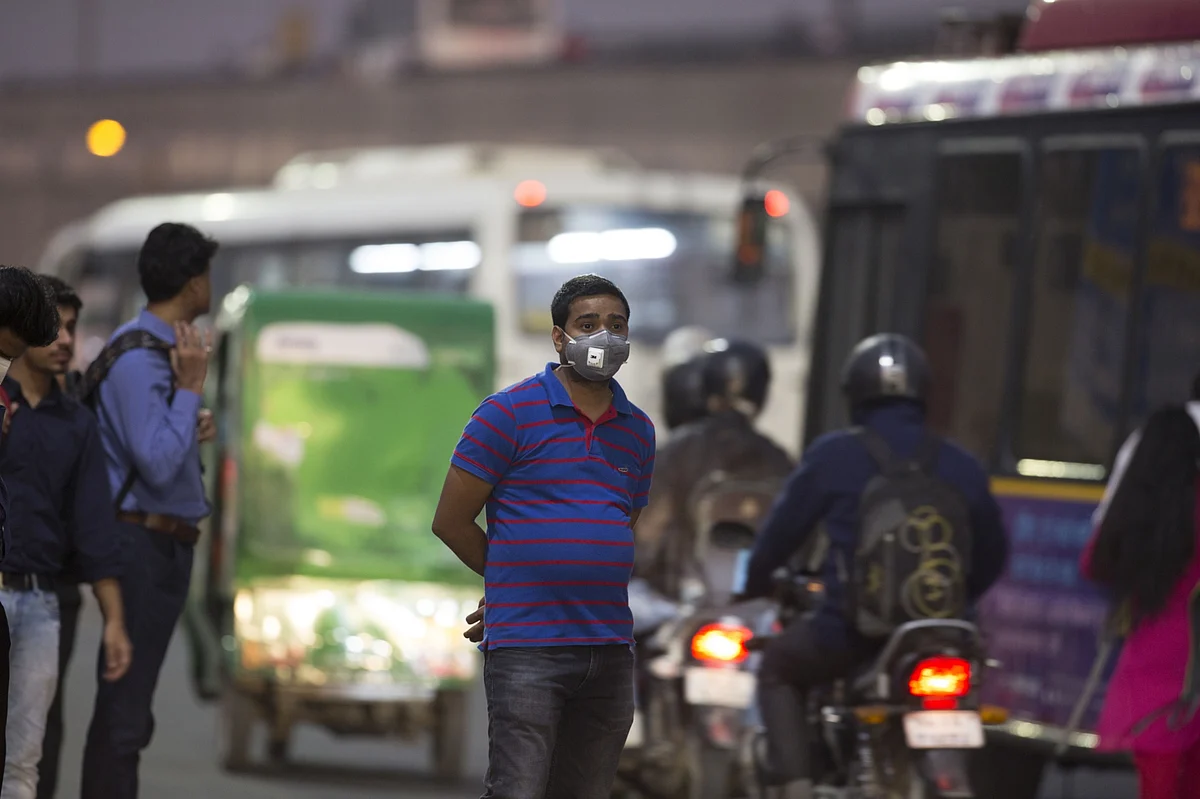 A commuter wears a mask while standing on the side of the road in Gurugram, Haryana, on Nov. 4, 2019. (Photographer: Ruhani Kaur/Bloomberg)