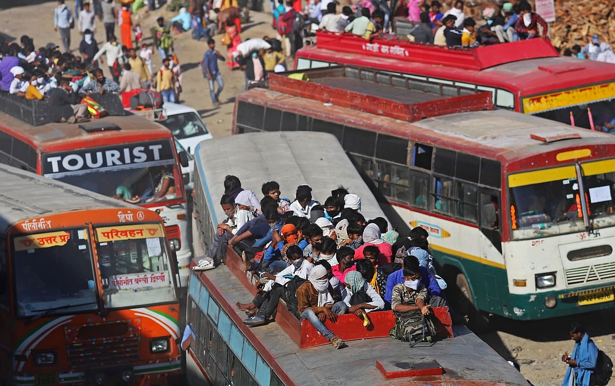 Migrant workers and their families sit atop a bus on the outskirts of Delhi during a lockdown imposed due to the coronavirus in Lalkuan, Uttarakhand, India. (Photographer: Anindito Mukherjee/Bloomberg)