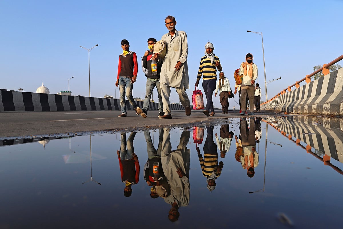 Migrant workers and their families walk along a road during a lockdown imposed due to the coronavirus in New Delhi, on  March 28, 2020. (Photographer: Anindito Mukherjee/Bloomberg)