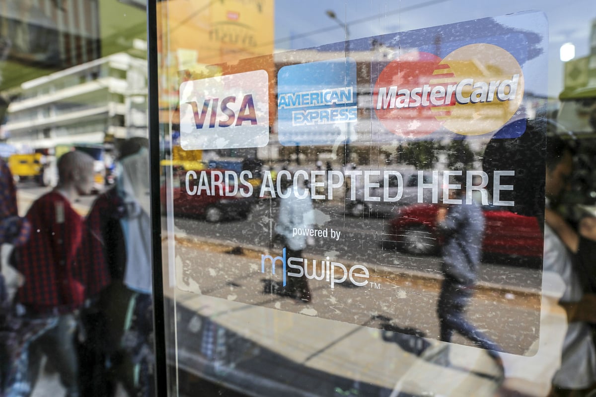 A sign showing logos of various electronic payment methods is displayed on the window of a s store in Bengaluru. (Photographer: Dhiraj Singh/Bloomberg)