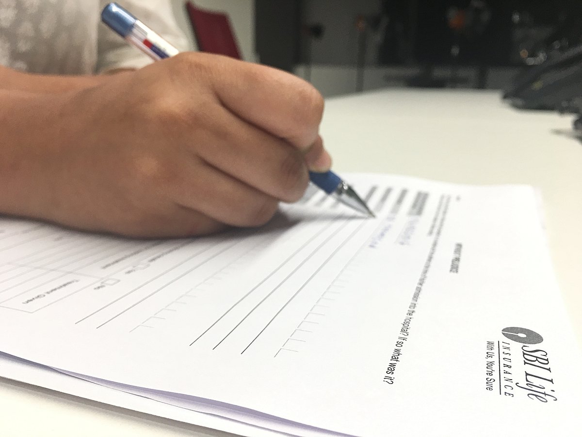 <div class="paragraphs"><p>A person filling SBI Life Insurance form. (Source: NDTV Profit)</p></div>