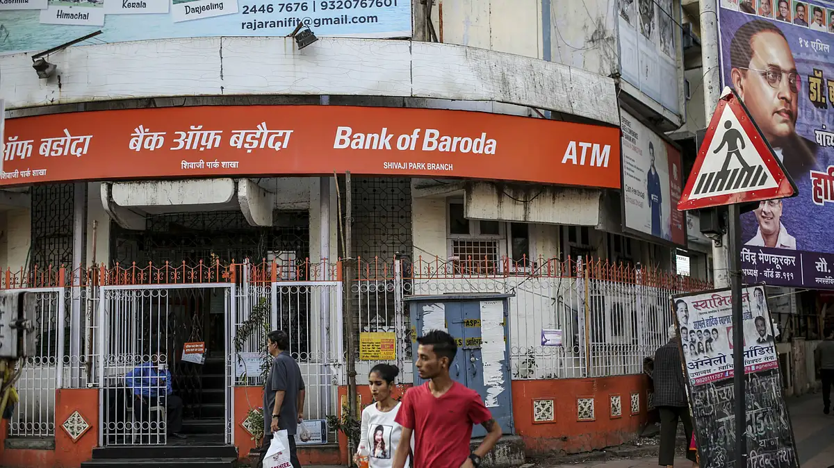 Pedestrians walk past a Bank of Baroda (BOB) branch in Mumbai, India. (Photographer: Dhiraj Singh/Bloomberg)